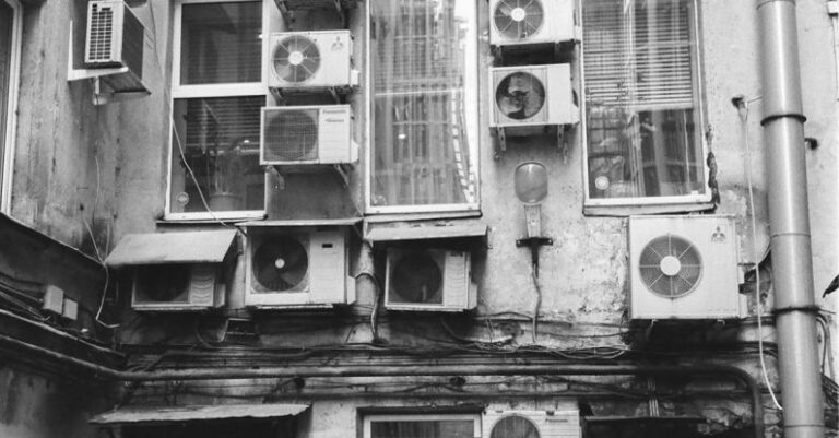 Air Conditioner - Air conditioners on old building in backyard