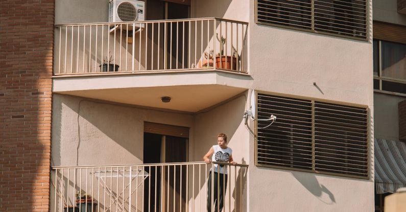 Air Conditioner - A Person Standing on the Balcony