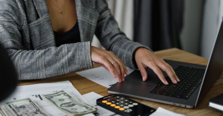 AC Budget - A Woman in Plaid Blazer Using Her Laptop