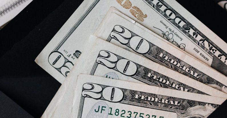 AC Budget - Stack of dollars and black envelope with banknotes inside