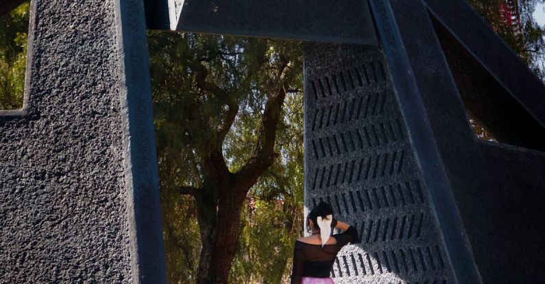 AC Installation - A woman in a pink skirt is standing in front of a large sculpture