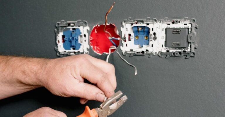 AC Maintenance - Crop faceless electrician using pliers for installation sockets and switches in new apartment