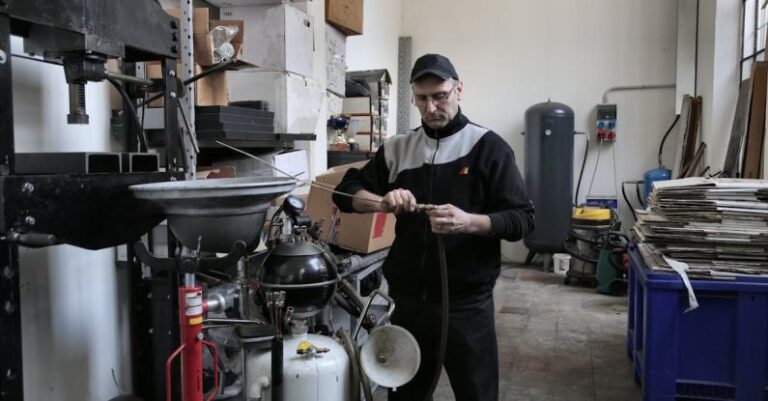 AC Troubleshooting - Focused mechanic repairing compressor hose in workshop