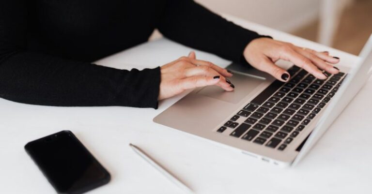 AC Plan - Crop faceless woman working on netbook in office