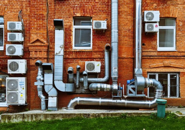 Air Conditioner - a building with a bunch of pipes on the side of it