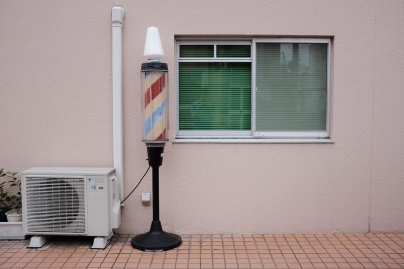 Air Conditioner - barber's lamp beside air condenser